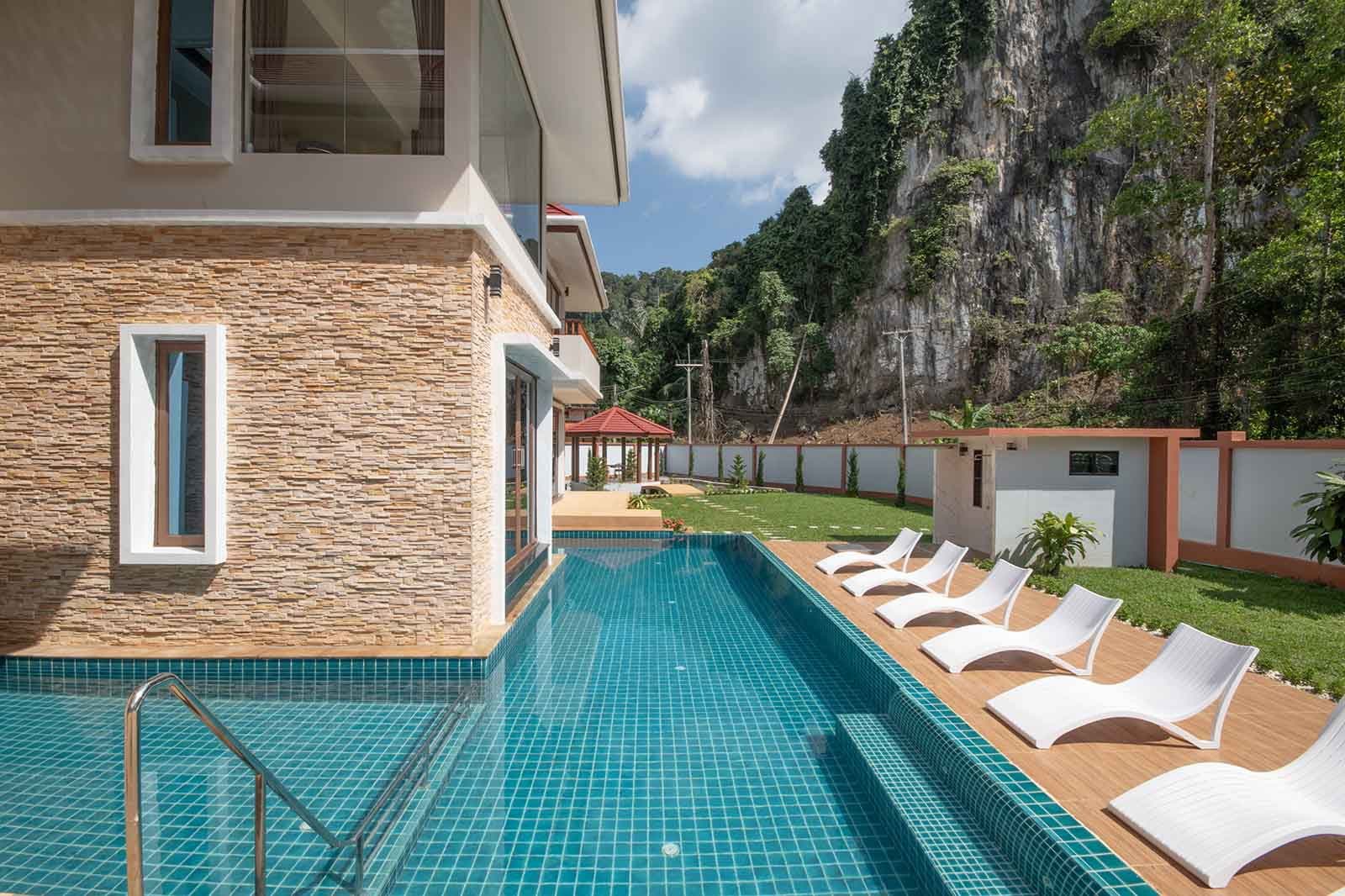 The pool, with the limestone karst rising behind the villa