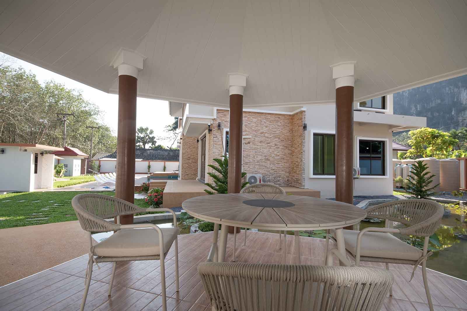 The covered sala and its dining table, out over the lotus pond